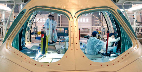 Four operators working on a fuselage section